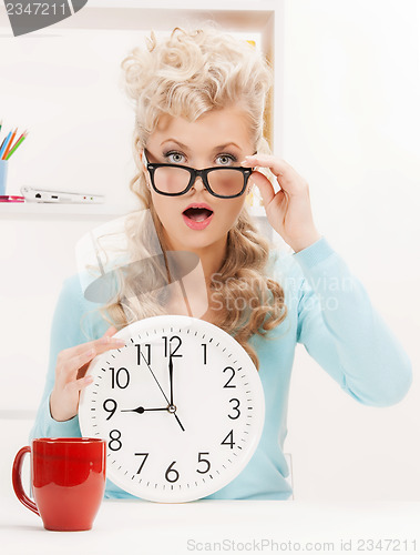 Image of wondering businesswoman with clock