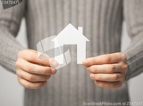 Image of man holding paper house