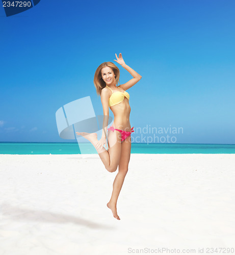 Image of happy jumping woman on the beach