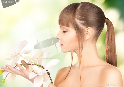 Image of beautiful woman with orchid flower