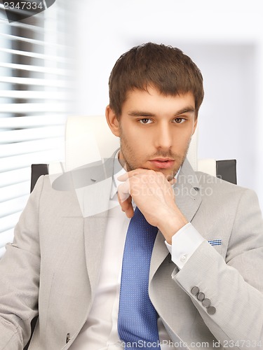 Image of young businessman sitting in chair