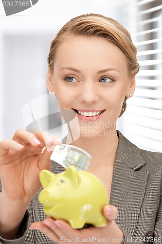 Image of lovely woman with piggy bank and money