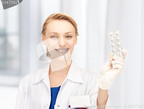 Image of attractive female doctor with pills