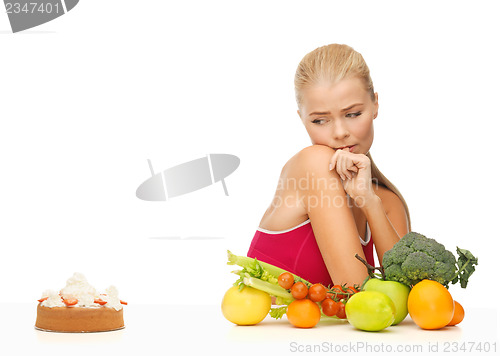 Image of doubting woman with fruits and hamburger