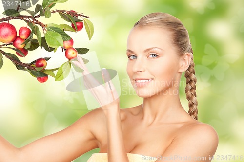 Image of lovely woman with apple twig and butterflies
