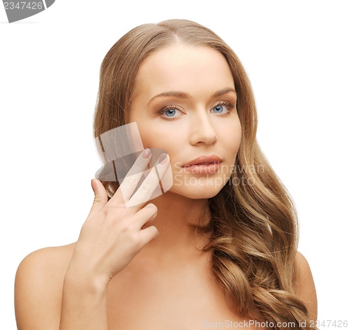 Image of beautiful woman pointing to cheek