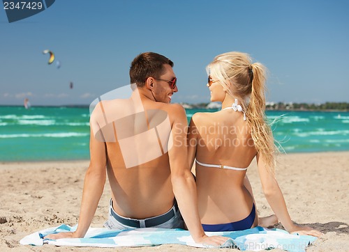 Image of happy couple in sunglasses on the beach