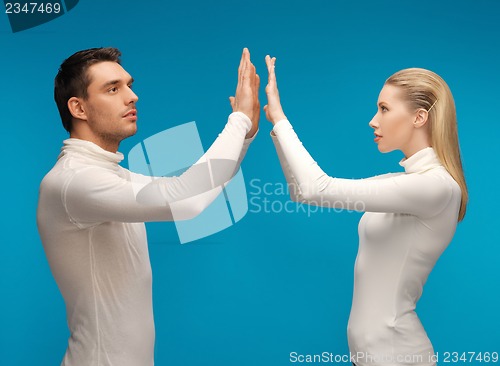 Image of man and woman working with something imaginary