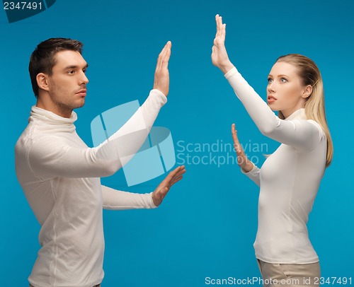 Image of man and woman working with something imaginary