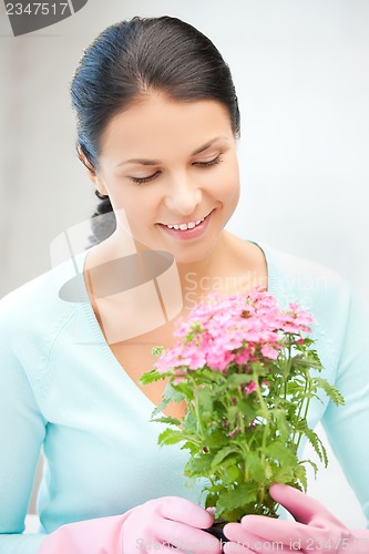 Image of lovely housewife with flower in pot