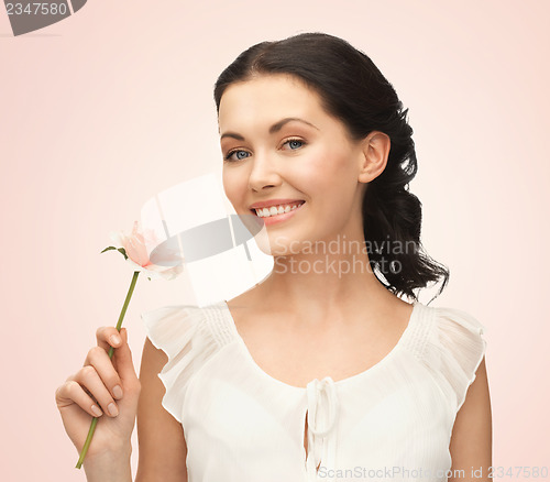 Image of young and beautiful woman with flower