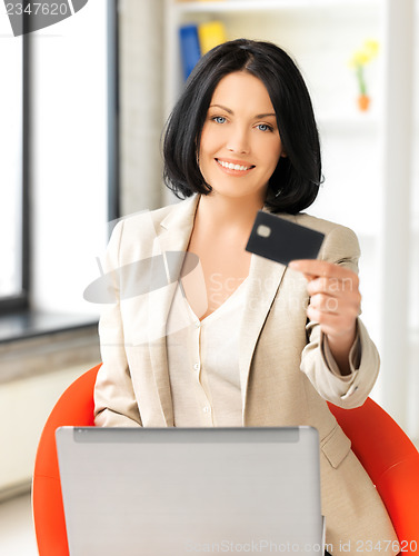 Image of businesswoman with laptop showing credit card