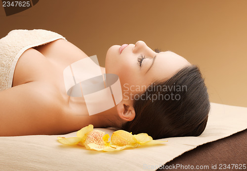 Image of woman in spa salon lying on the massage desk