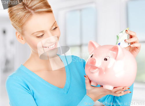 Image of lovely woman with piggy bank and money