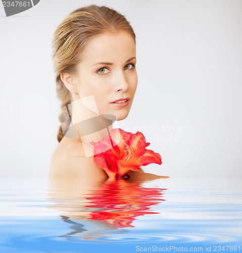 Image of lovely woman with lily flower in water