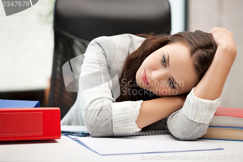 Image of bored and tired woman behid the table