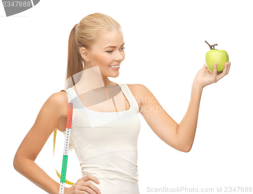 Image of sporty woman with apple and measuring tape