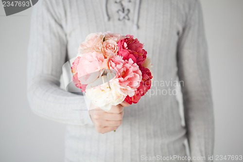 Image of man holding bouquet of flowers