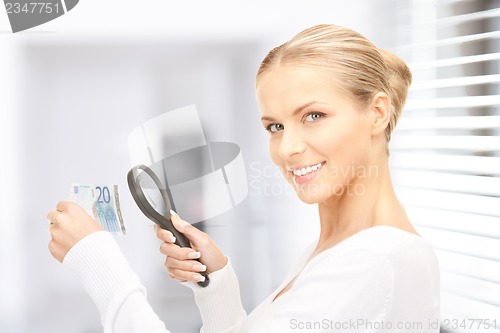 Image of woman with magnifying glass and money