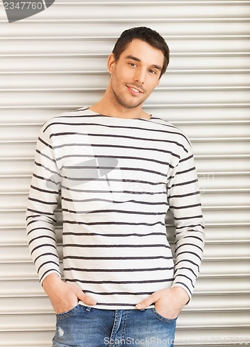 Image of handsome man in casual clothes leaning to wall