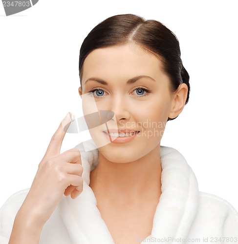 Image of woman in bathrobe applying creme
