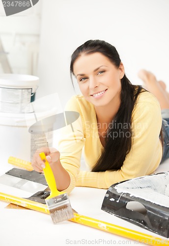 Image of woman with paintbrush and renovating tools