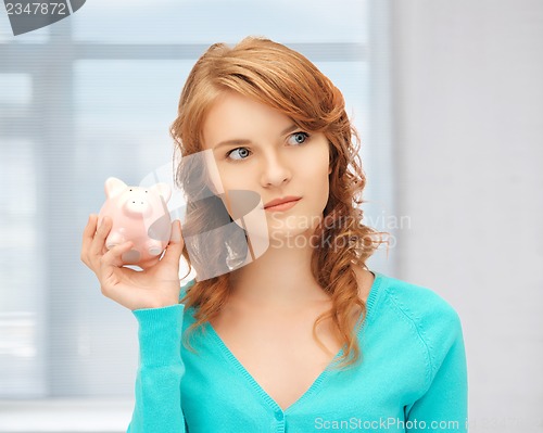 Image of teenage girl with piggy bank