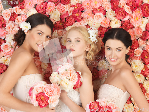 Image of three women with background full of roses