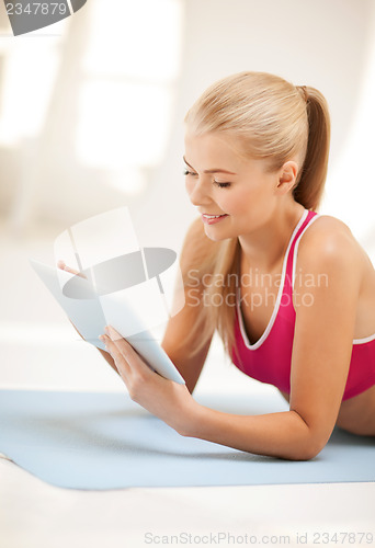 Image of woman lying on the floor with tablet pc