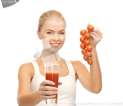 Image of woman holding glass of juice and tomatoes