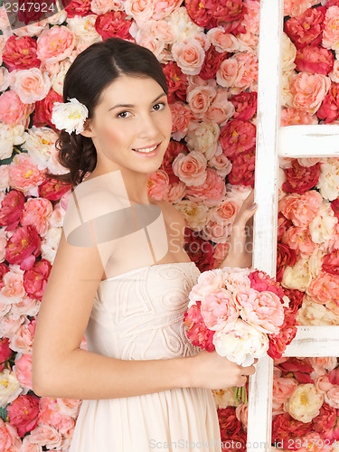 Image of woman with bouquet and background full of roses