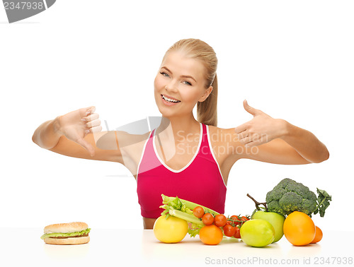 Image of woman with fruits and hamburger comparing food