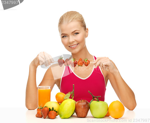 Image of woman with organic food eating strawberry
