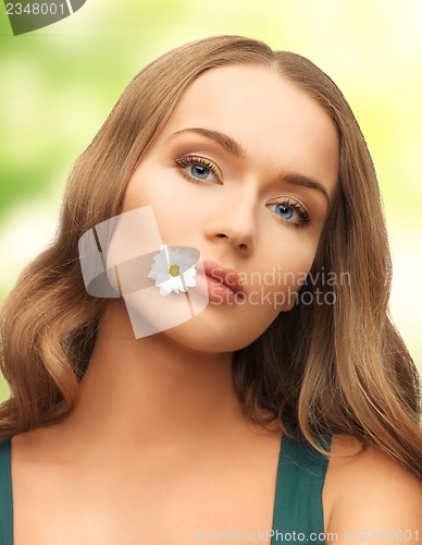 Image of woman with camomile in mouth