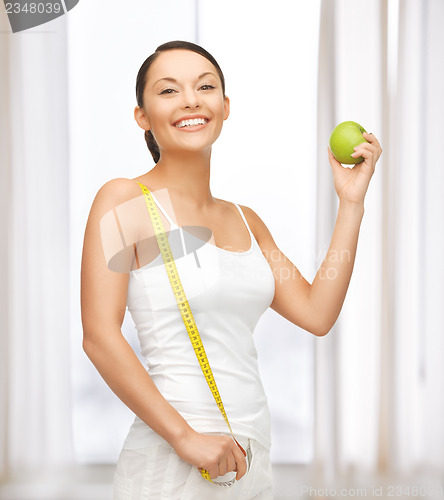 Image of sporty woman with apple and measuring tape