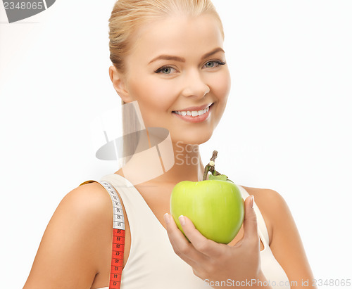 Image of sporty woman with apple and measuring tape