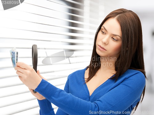 Image of woman with magnifying glass and euro cash money