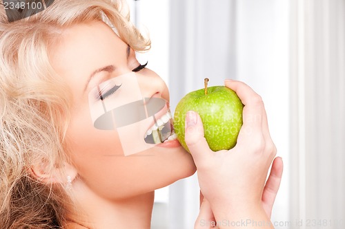Image of young beautiful woman with green apple