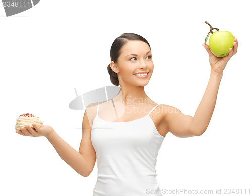 Image of sporty woman with apple and cake