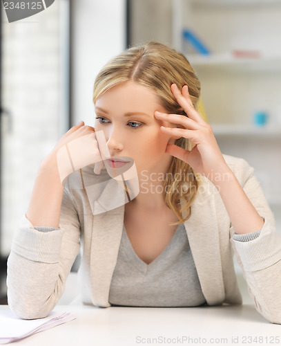 Image of bored and tired woman behind the table
