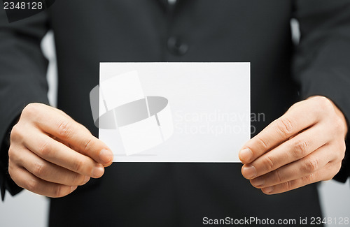 Image of man in suit holding blank card