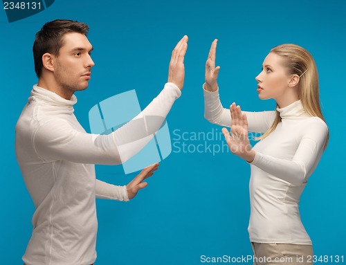 Image of man and woman working with something imaginary
