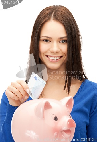 Image of lovely woman with piggy bank and money