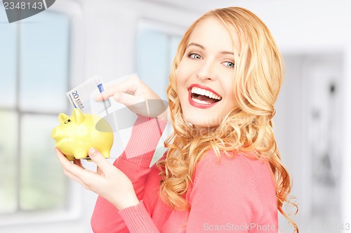 Image of lovely woman with piggy bank and money