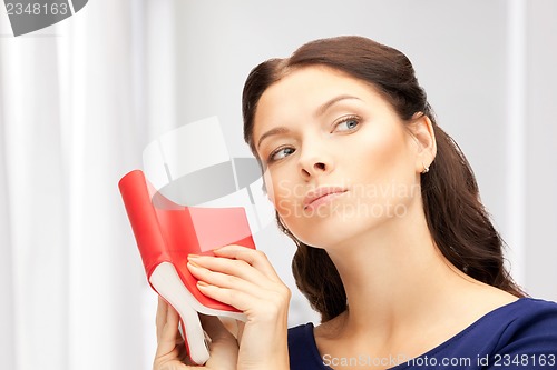 Image of calm and serious woman with book