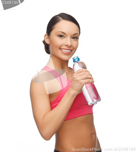 Image of sporty woman drinking water from bottle