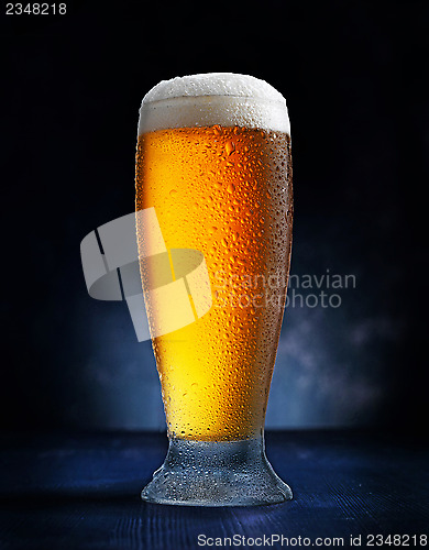 Image of glass of beer on dark blue background