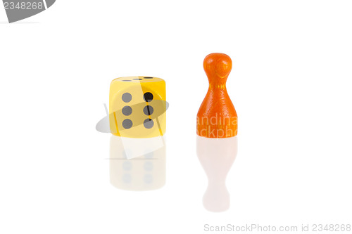 Image of One orange pawn and a yellow dice 