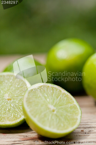 Image of green fresh lime on wooden table macro closeup outdoor