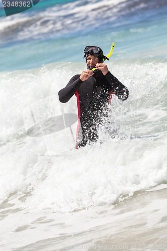 Image of male diver with diving suit snorkel mask fins on the beach